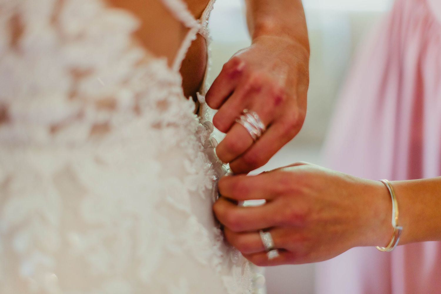 Close-up details of wedding rings and hands during a special moment.