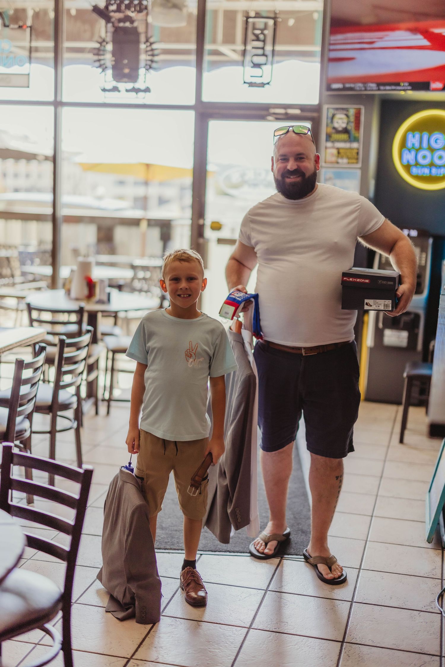 Customers standing inside a casual dining establishment with storefront windows.
