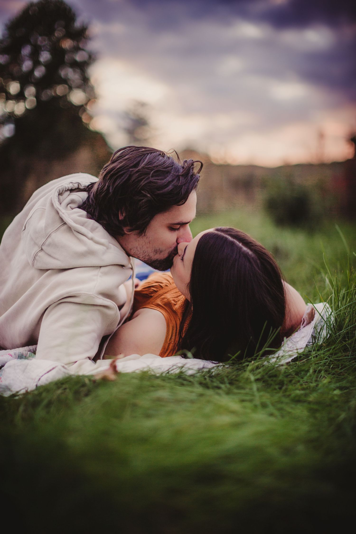 A romantic outdoor photoshoot in tall grass during golden hour.