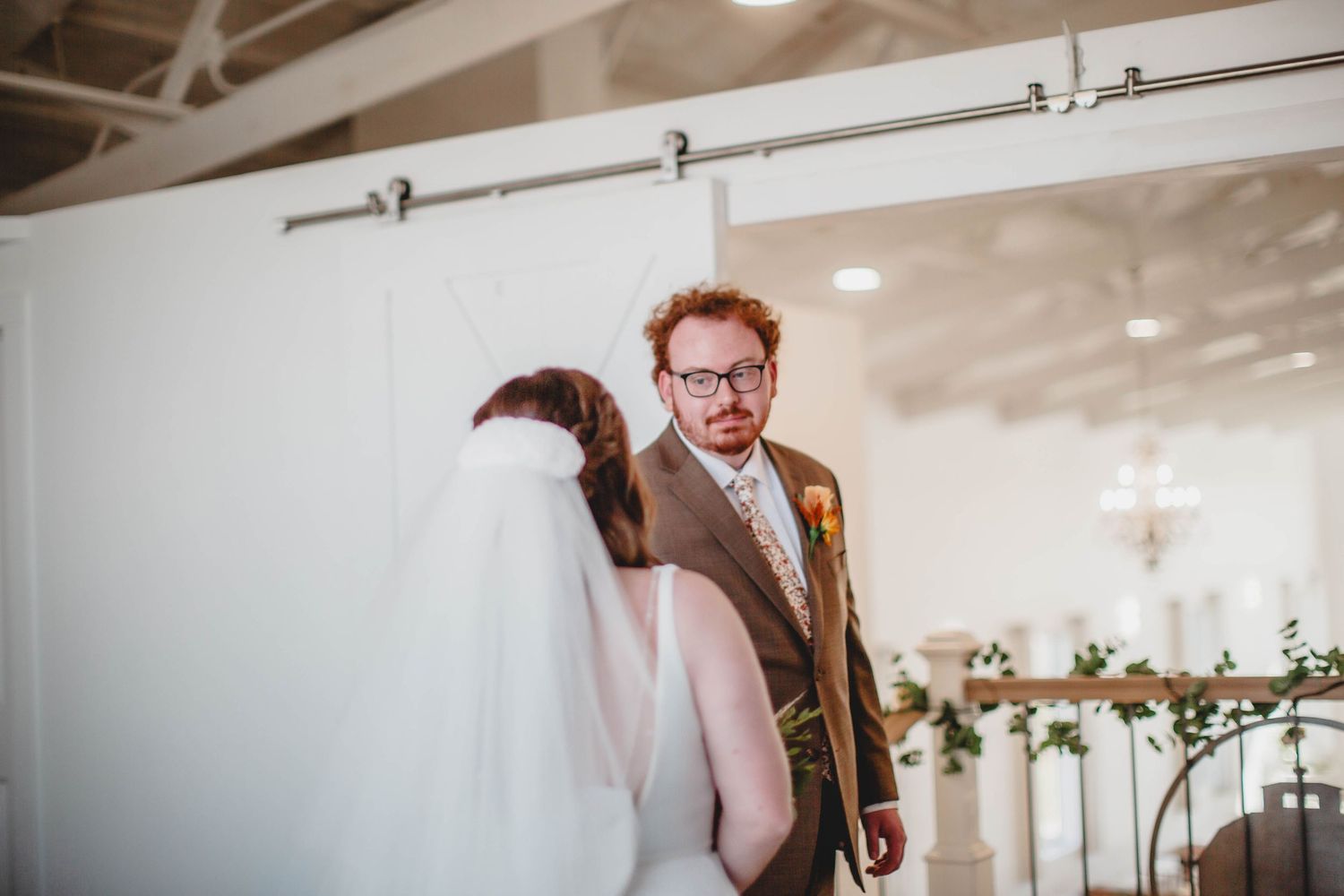 A bright wedding venue with high ceilings and elegant floral decorations.
