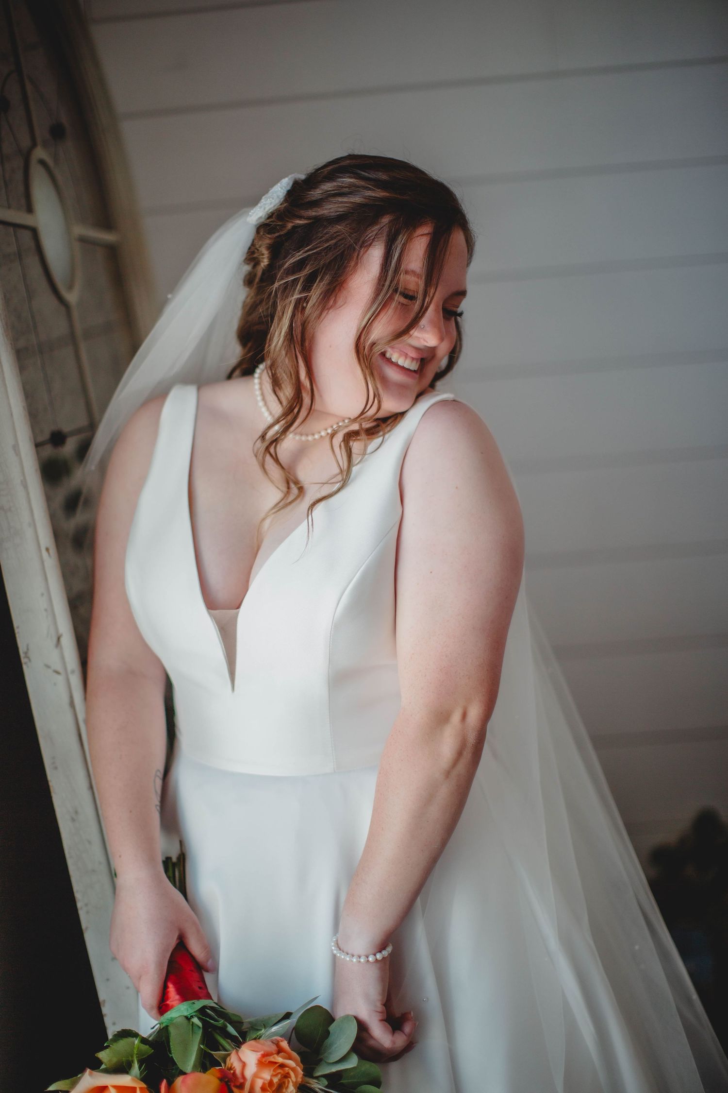 A candid moment shows genuine joy during bridal portraits with fall flowers.