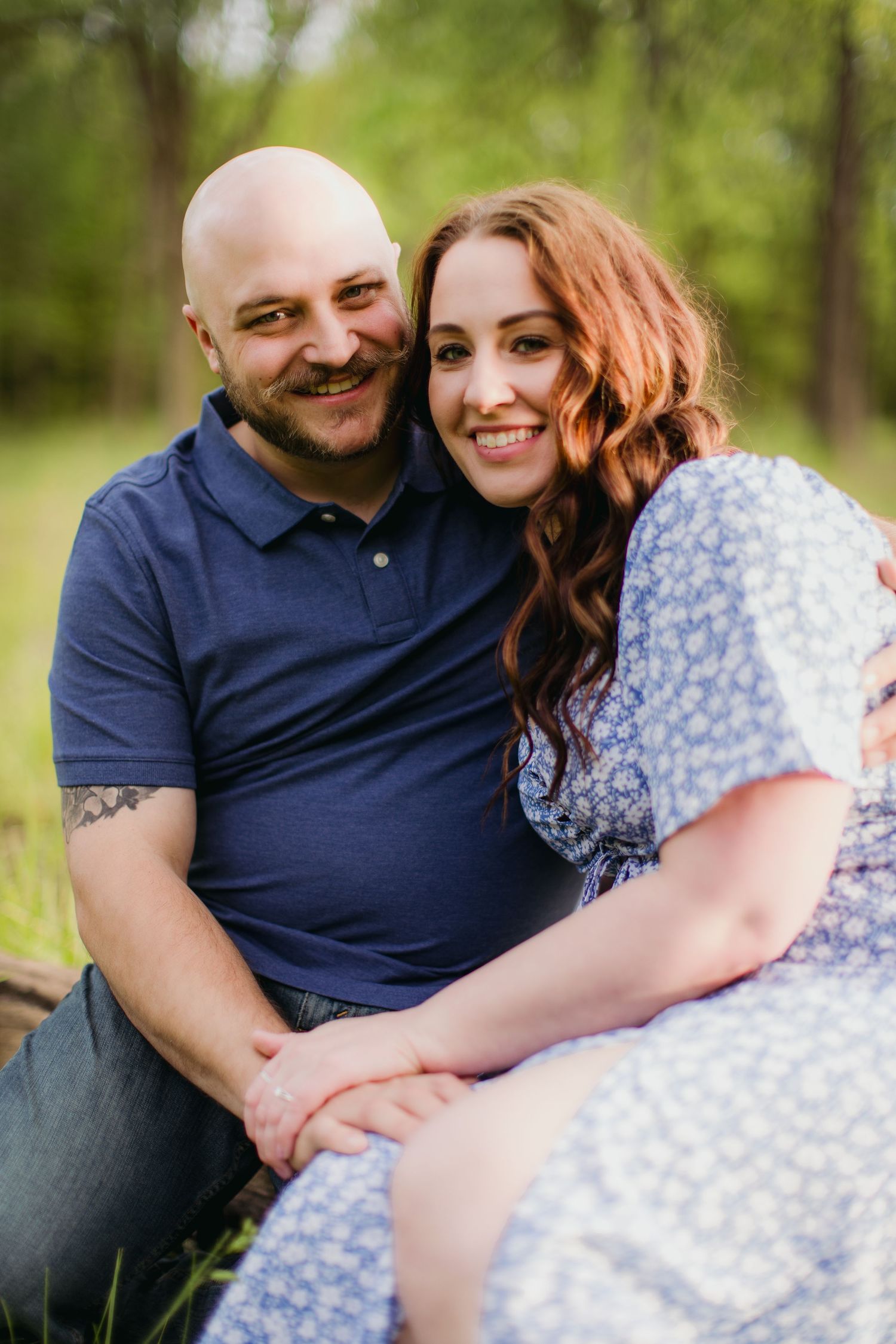 Joyful outdoor portrait of a couple in coordinating blue and floral outfits.