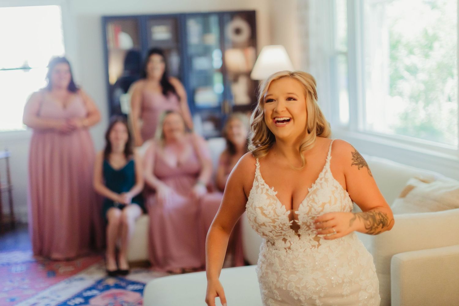 A bride in a white lace gown dances joyfully during her wedding celebration.
