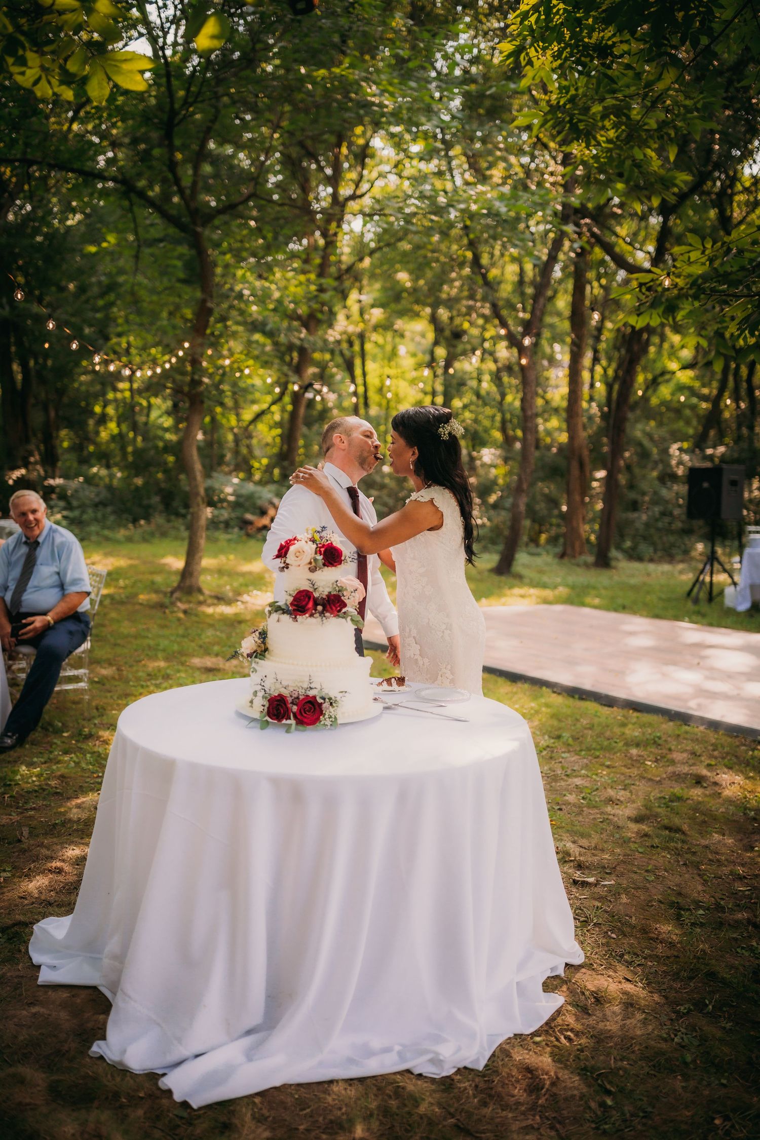 Marriage ceremony documentation moment at sunset with decorated cake and forest background.