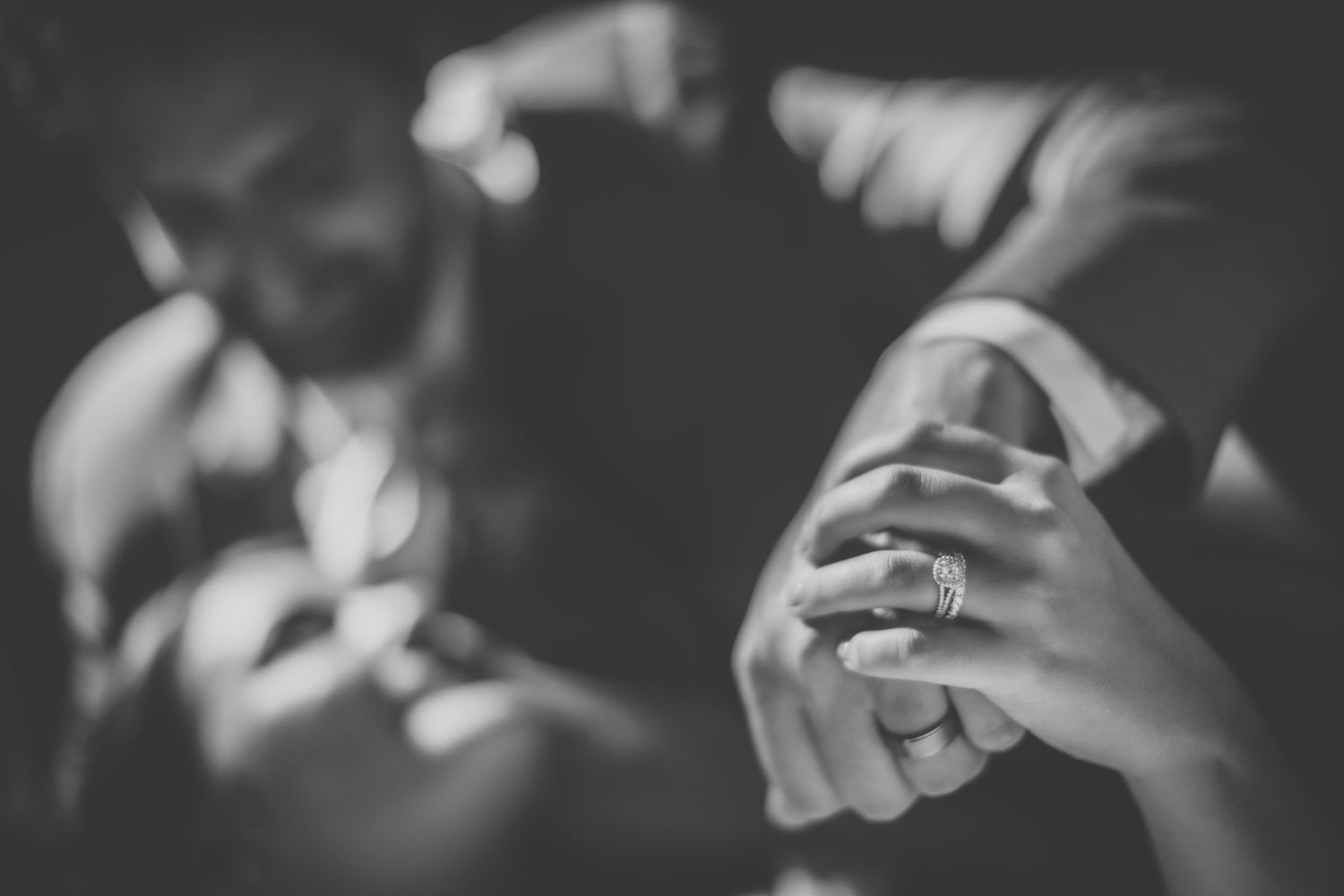 Close-up detail of hands during an intimate wedding moment.