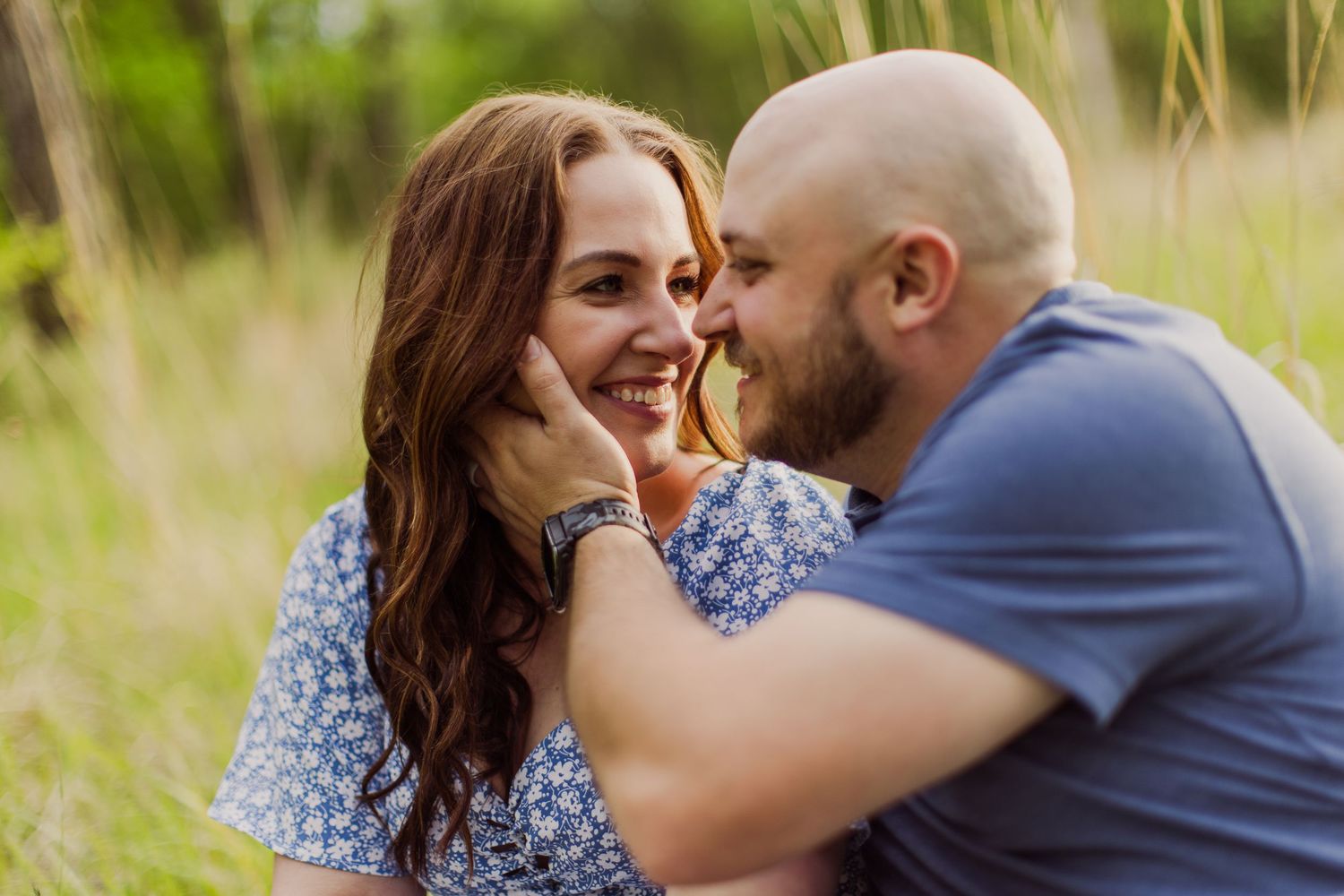 A romantic couple shares a tender kiss during their outdoor portrait session.