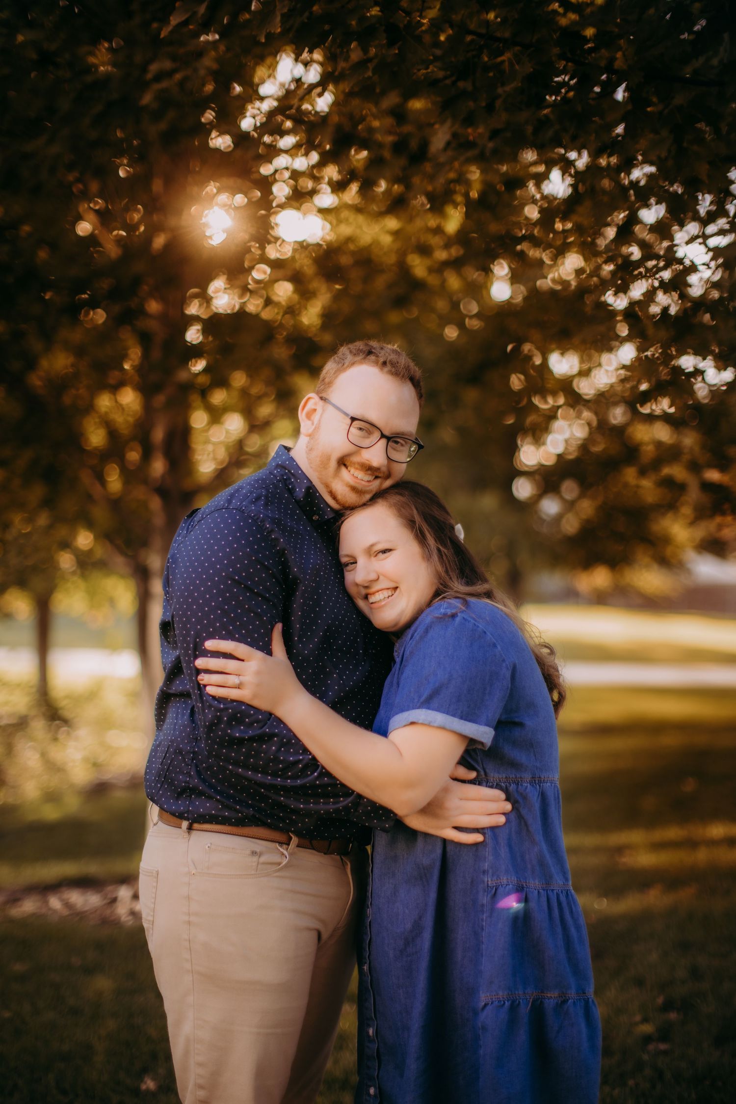 A romantic outdoor portrait of a couple embracing in golden sunlight with bokeh effects in autumn.