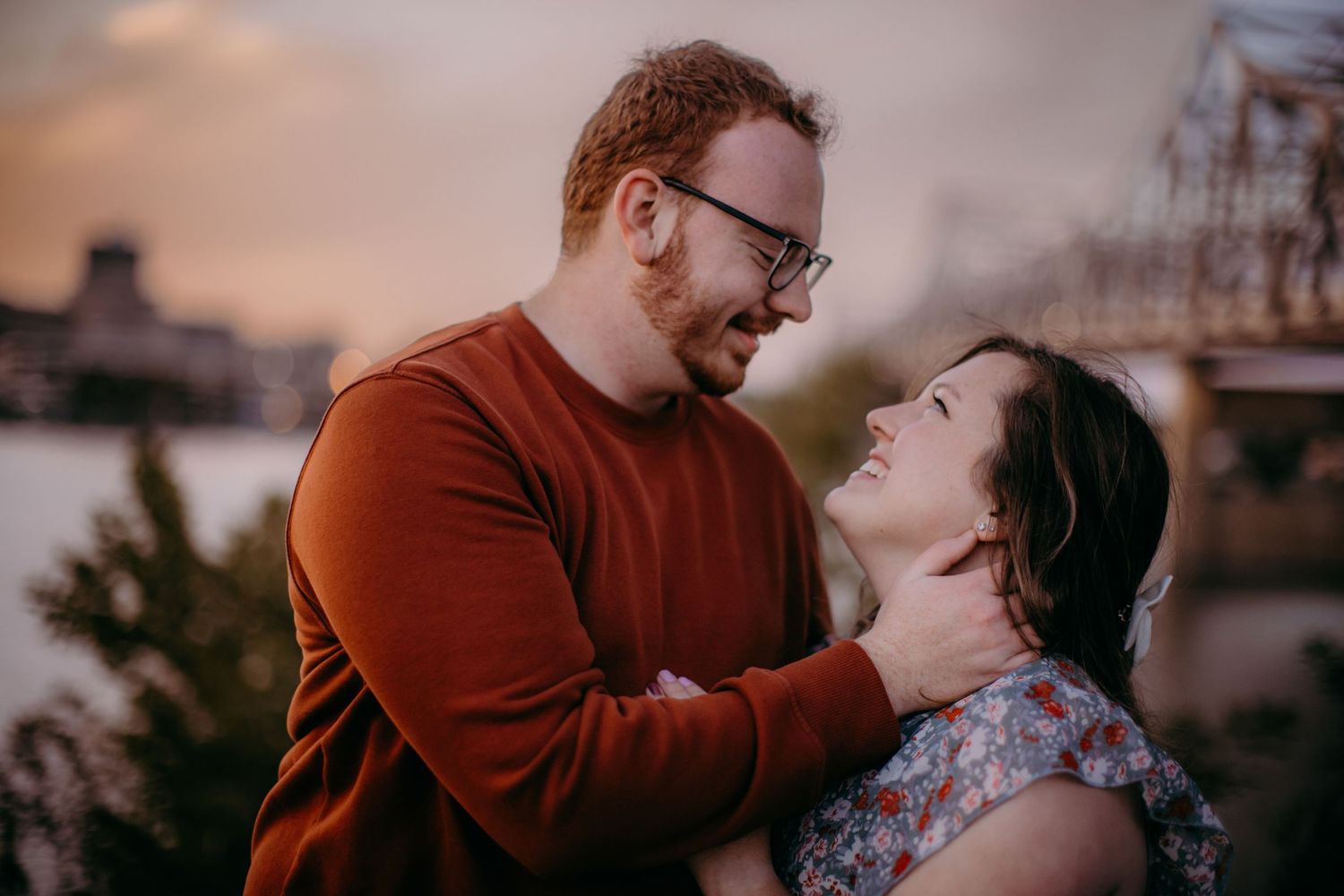 Close up of romantic couple moment with city waterfront and sunset in background.