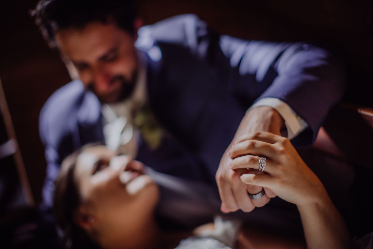 Intimate wedding portrait captured in dark, moody atmosphere.