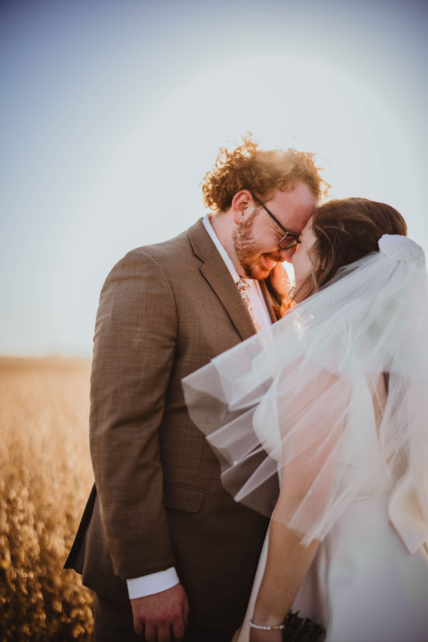 Intimate wedding portraits of a couple embracing against a dreamy outdoor backdrop.