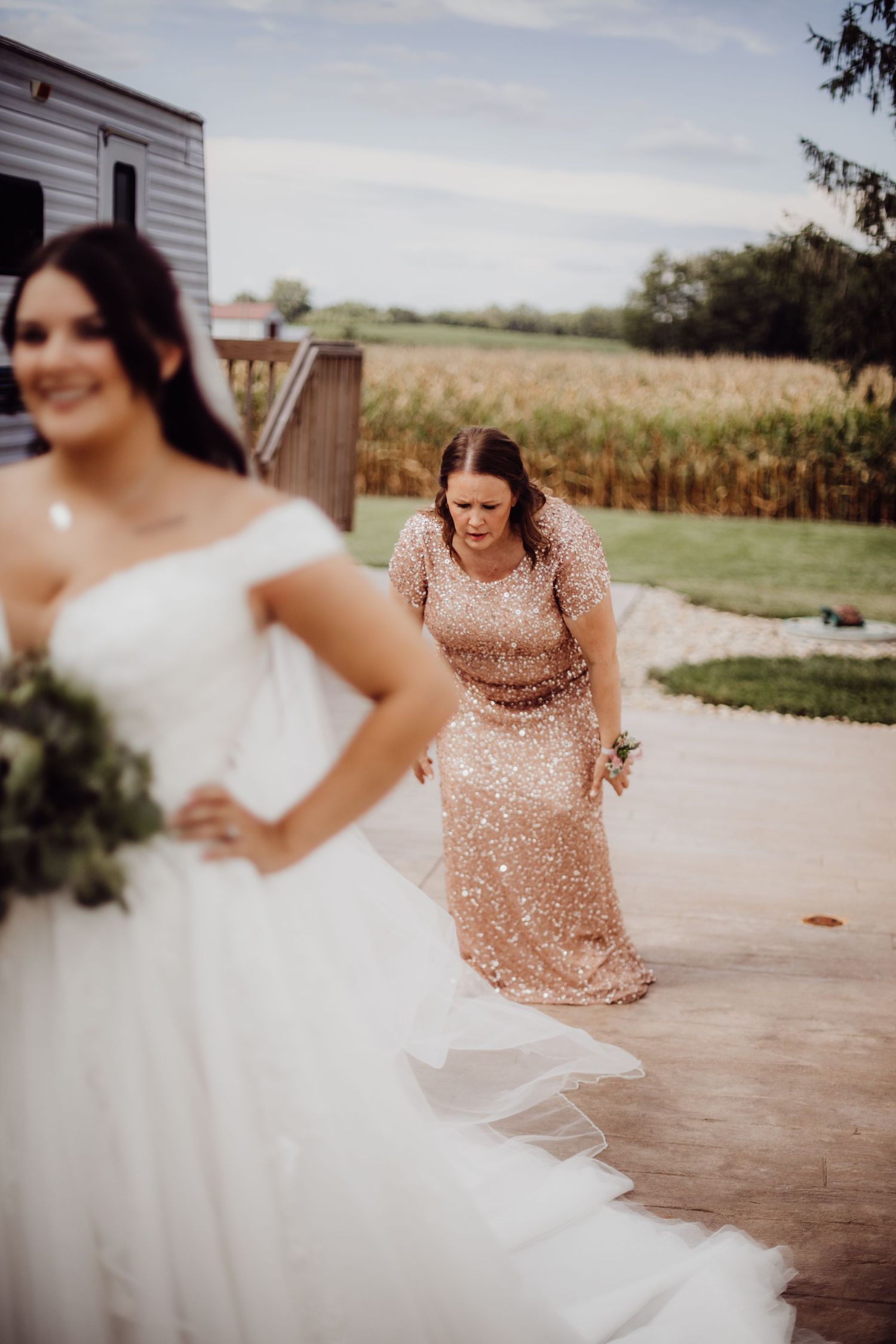 Playful wedding party interaction captured in outdoor rustic setting.