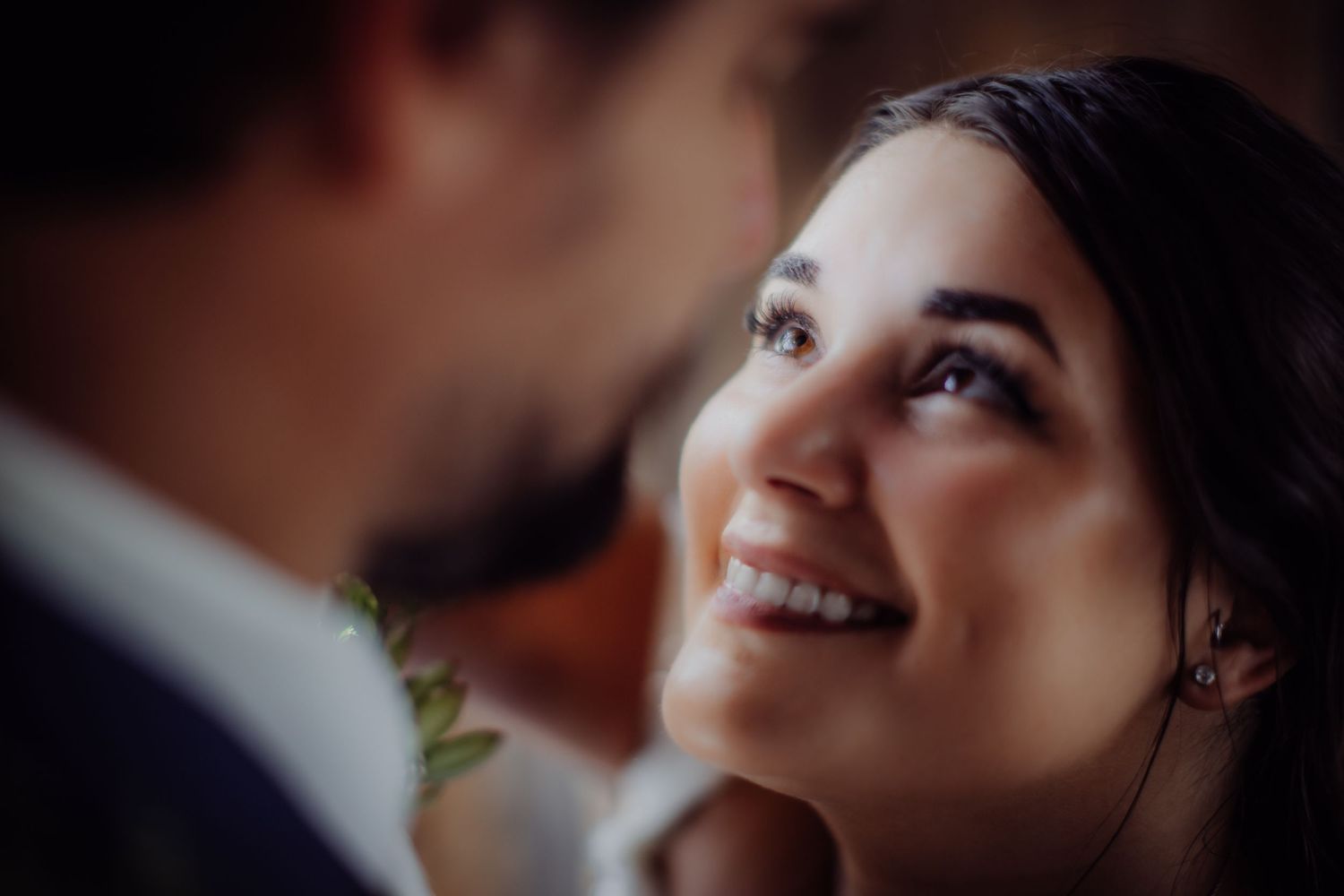 Candid wedding moment showing sweet emotions between newlyweds in rustic venue.