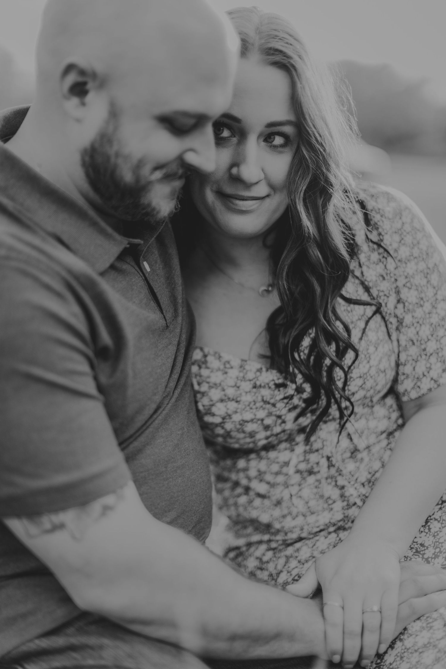 A black and white portrait capturing a tender moment between a couple during their engagement shoot.