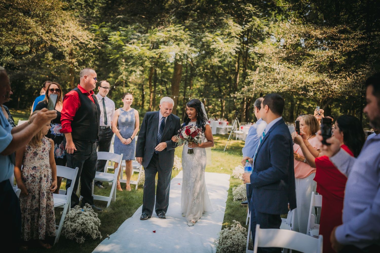 Wedding party and guests celebrating in an outdoor garden venue with natural decor.