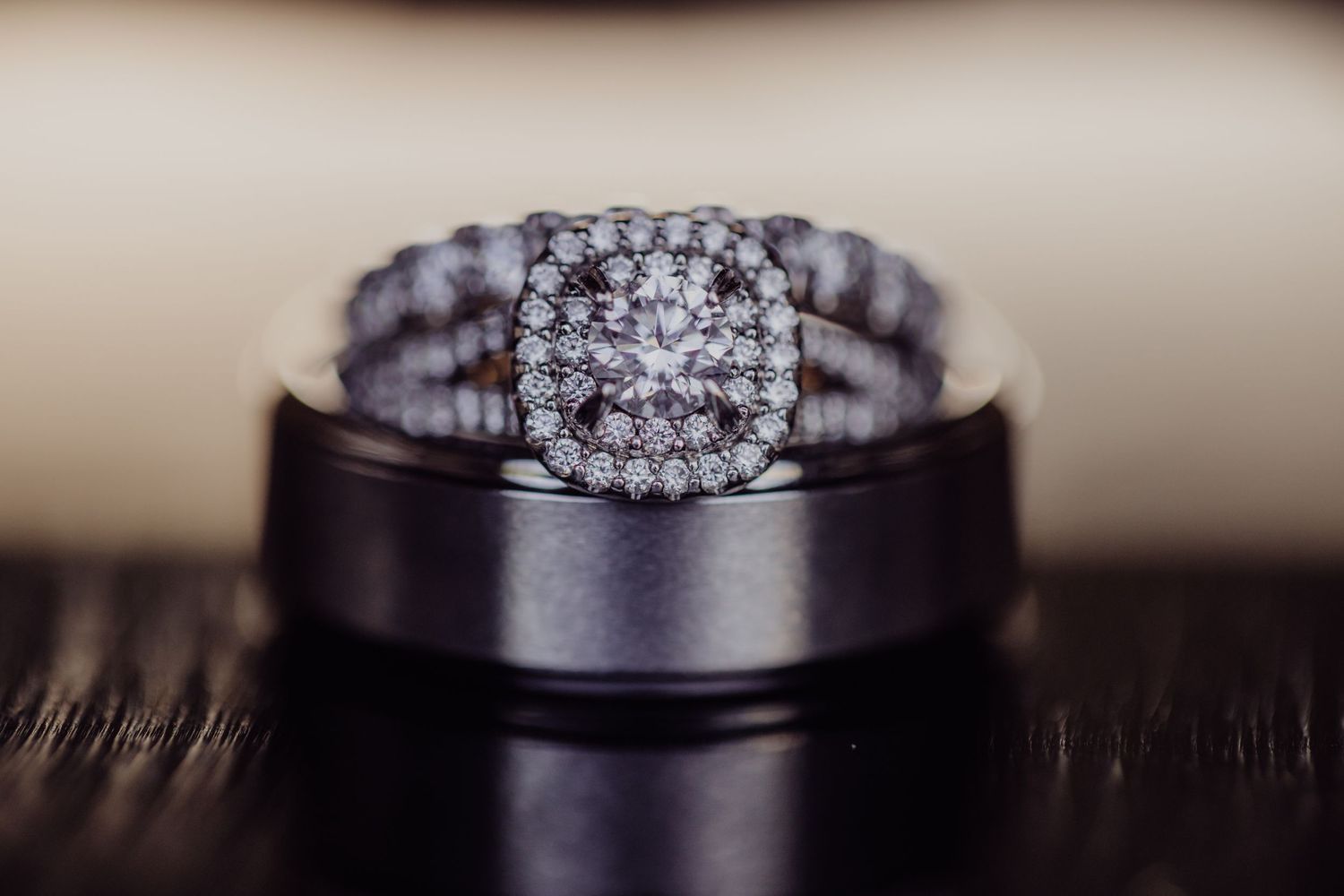 Diamond engagement ring and wedding band set against dark background.