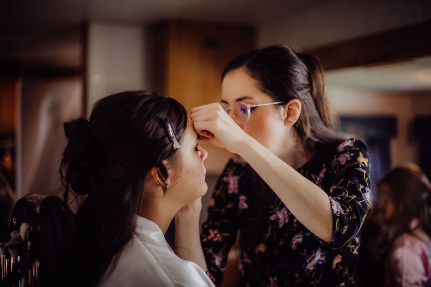 Professional makeup application in progress with focused attention to detail.