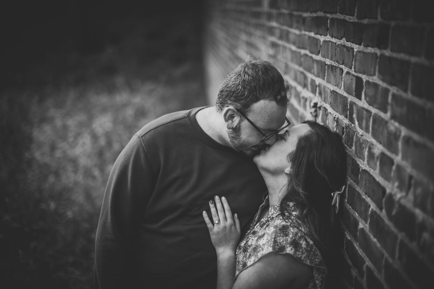 Artistic black and white photography showcases romantic gestures against industrial architecture.