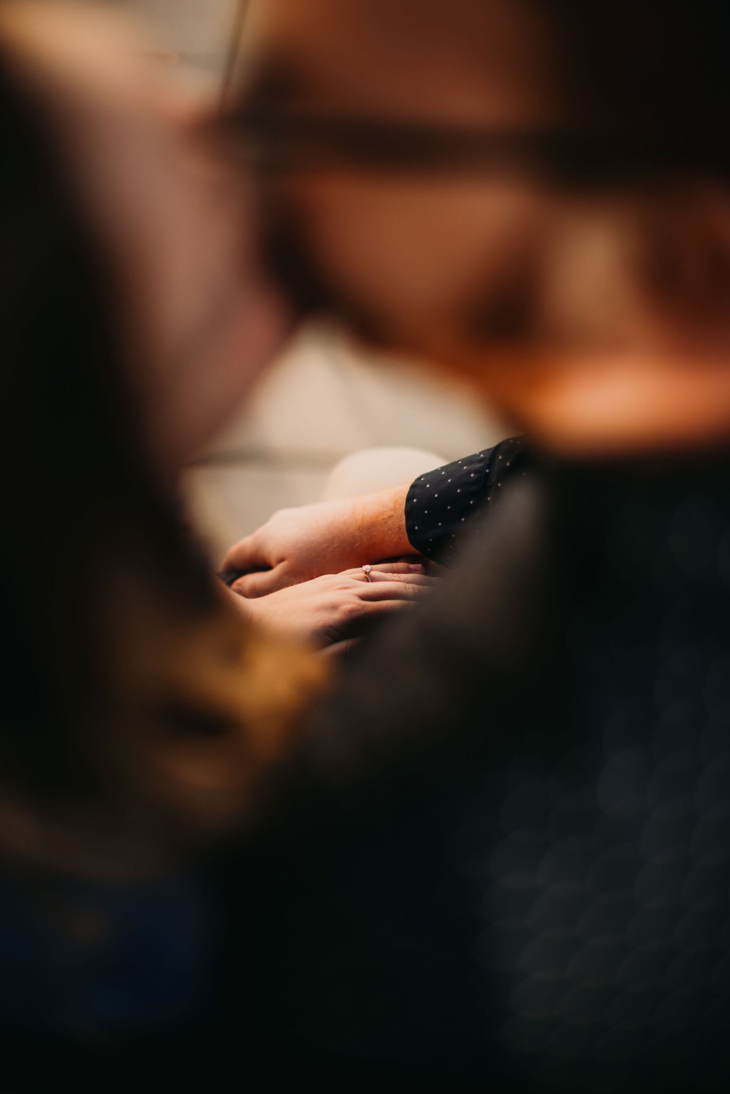 Close-up of hands with soft lighting and blurred background creating an intimate mood.