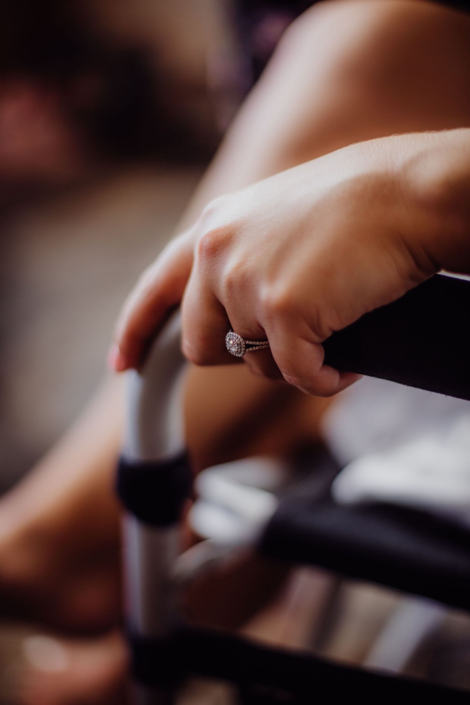 Close-up of an engagement ring while holding a makeup brush.