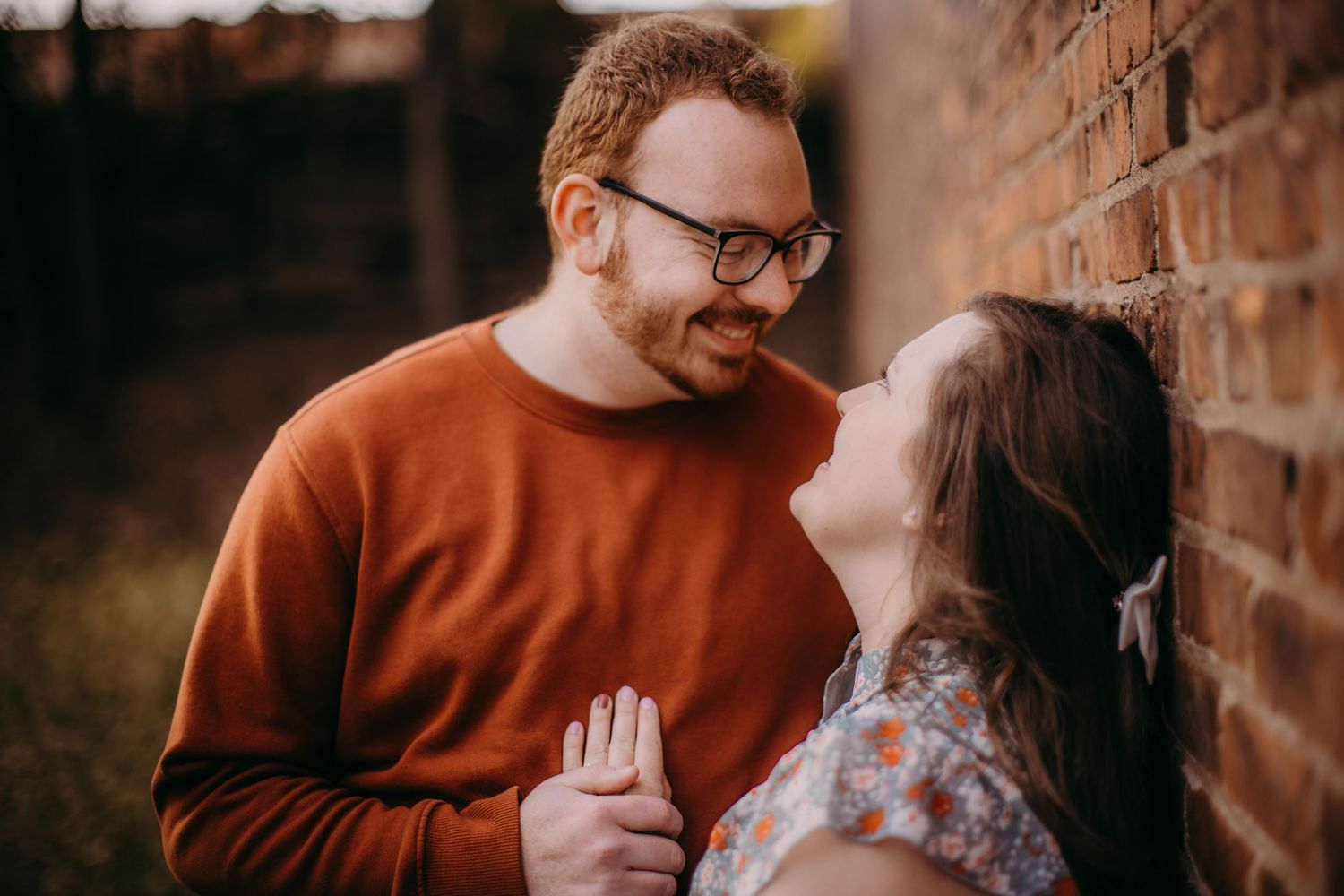 Natural light photography highlights tender moments during an urban engagement session.