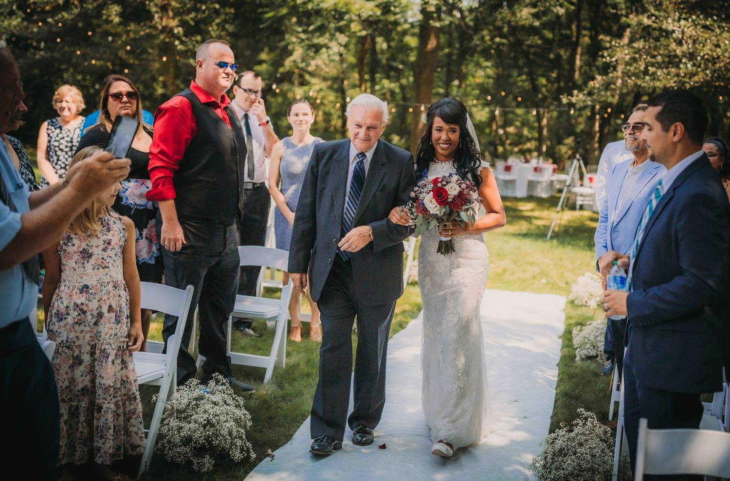 Guests celebrating at an elegant outdoor wedding surrounded by natural landscaping.