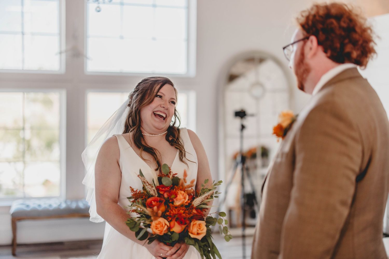 Intimate wedding scene with autumn-themed decor and natural window lighting.