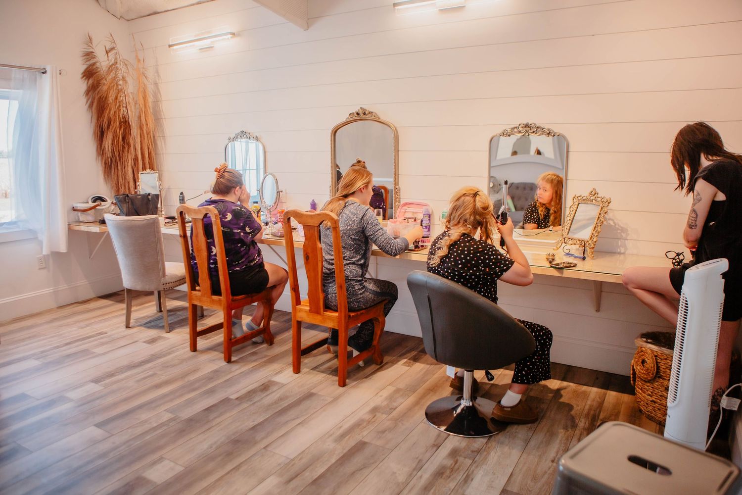 Interior of a bridal preparation room with makeup stations and mirrors.