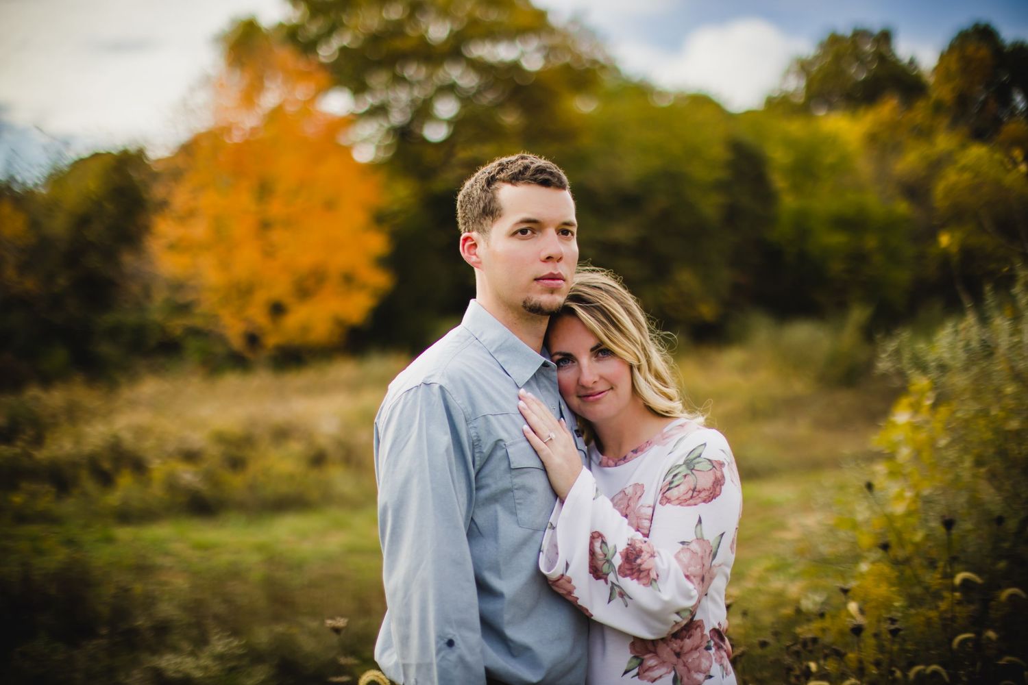 Romantic autumn portrait of a couple in front of fall foliage.