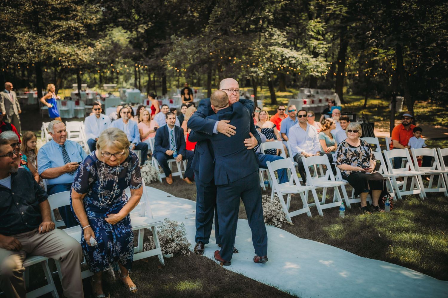Attendees observe a special moment during an outdoor garden wedding ceremony.