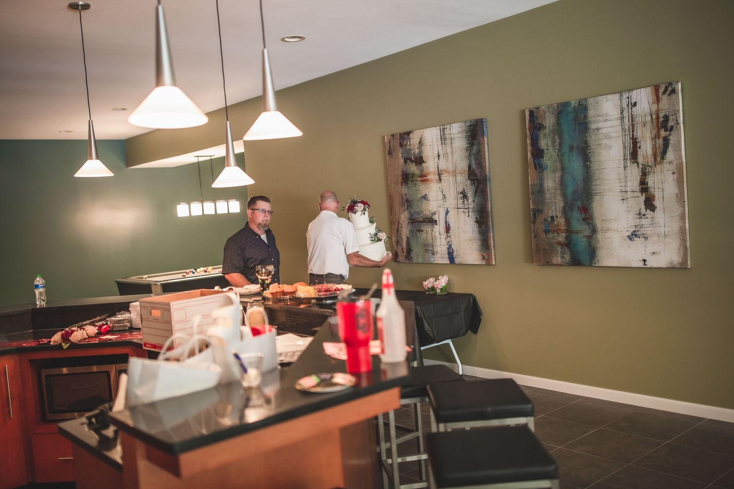 A staging area with refreshments and decorative art on sage green walls.