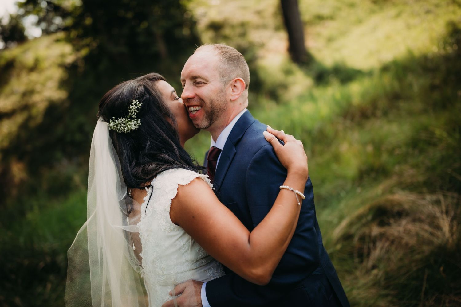 Romantic wedding portrait showing tender moment between newlyweds in natural outdoor lighting.