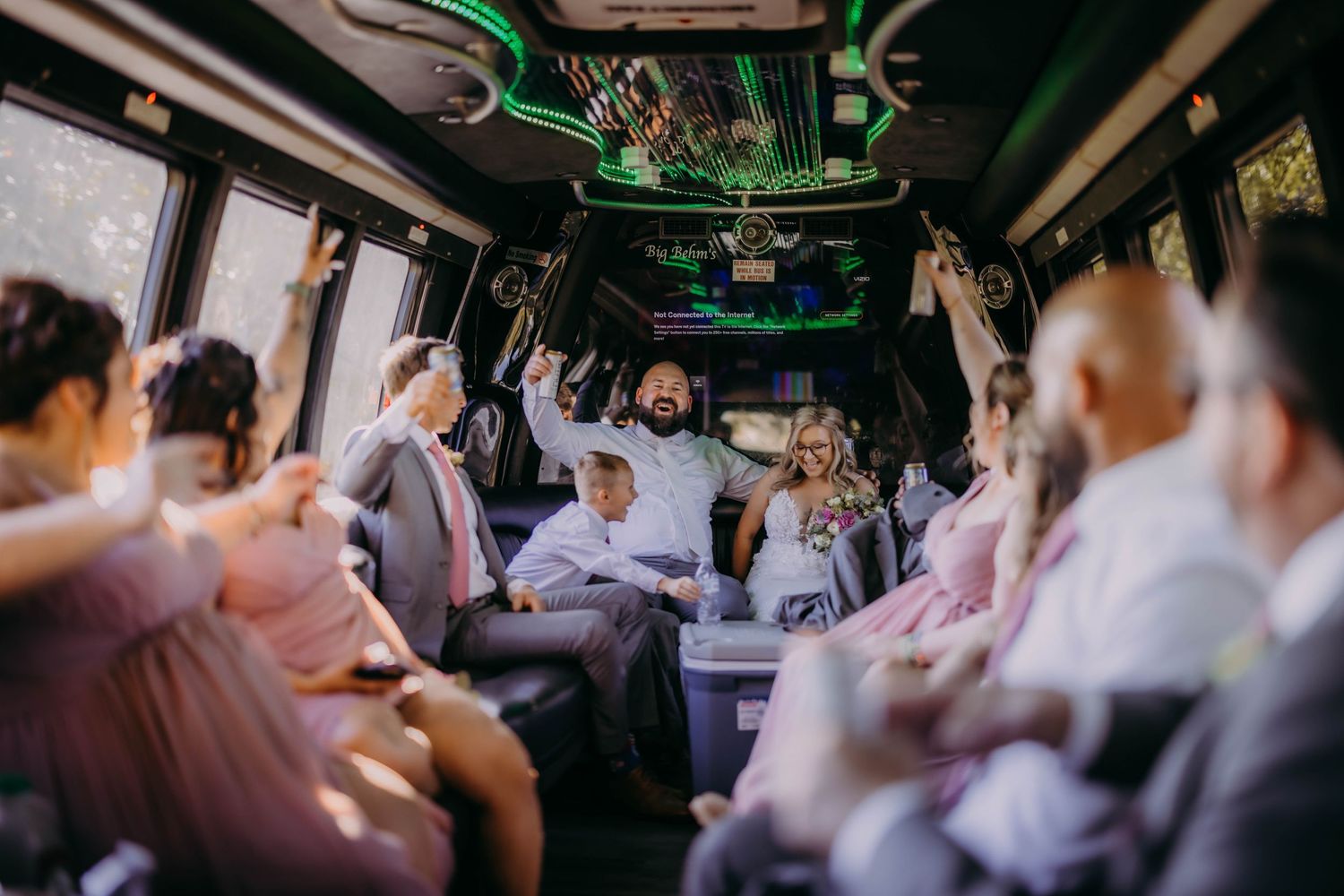 Wedding celebration continues inside party bus with festive atmosphere.