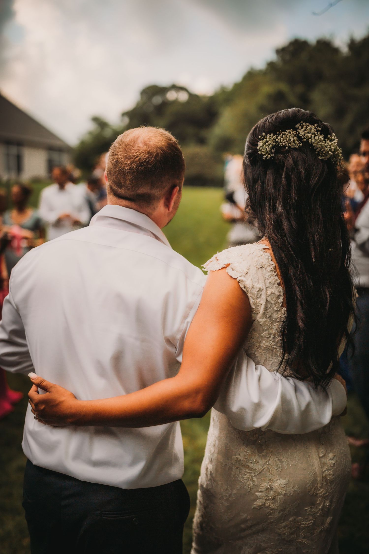 Back view of couple dancing at an outdoor wedding reception.