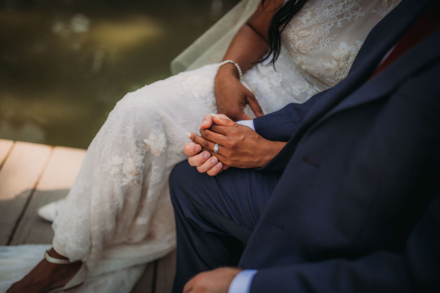 Close-up shots of a couple sitting together by the water during their wedding.