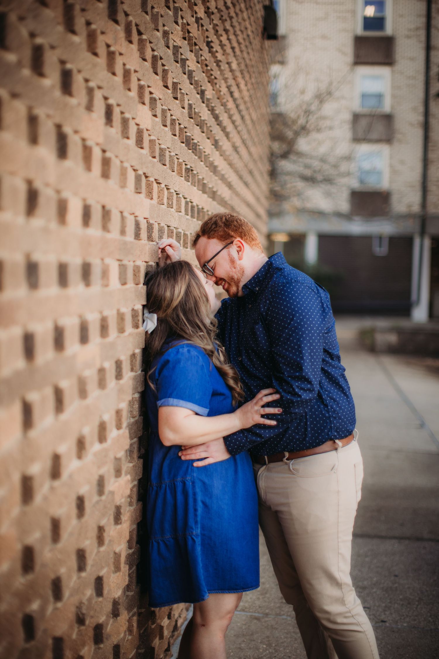 Sweet embrace against an architecturally interesting brick wall.