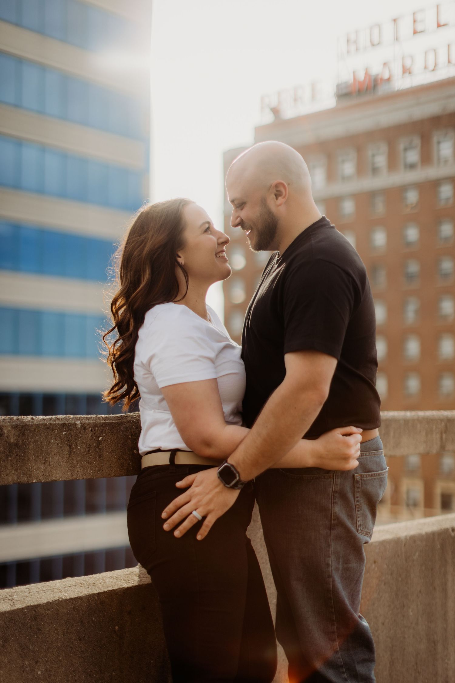 A couple shares a romantic moment during their rooftop photoshoot at golden hour.