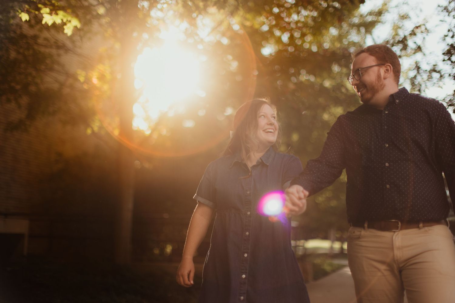 Romantic photoshoot with dramatic sunburst through trees.