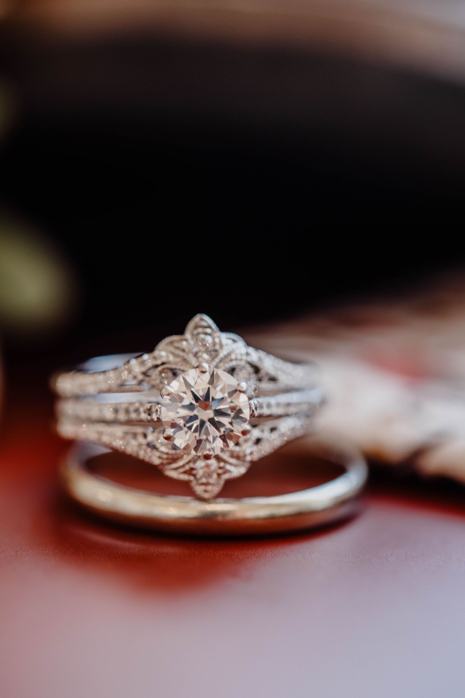 A detailed close-up of a vintage-style diamond engagement ring with intricate metalwork.