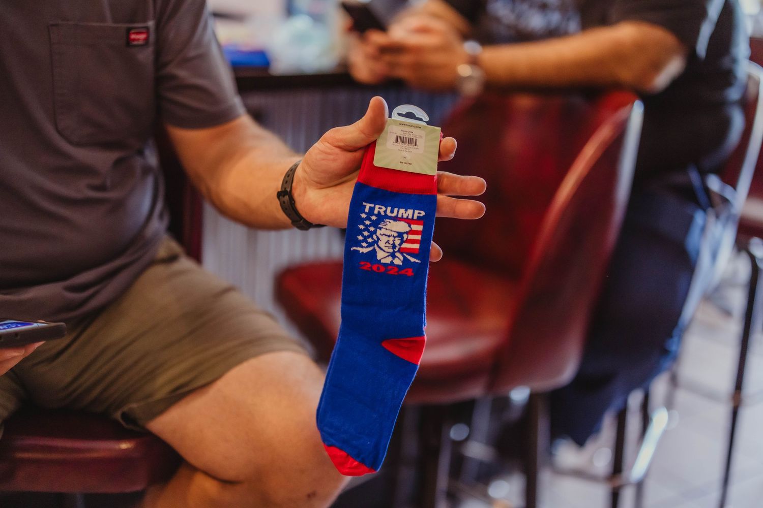 Hand holding a patriotic blue sock with American flag design.