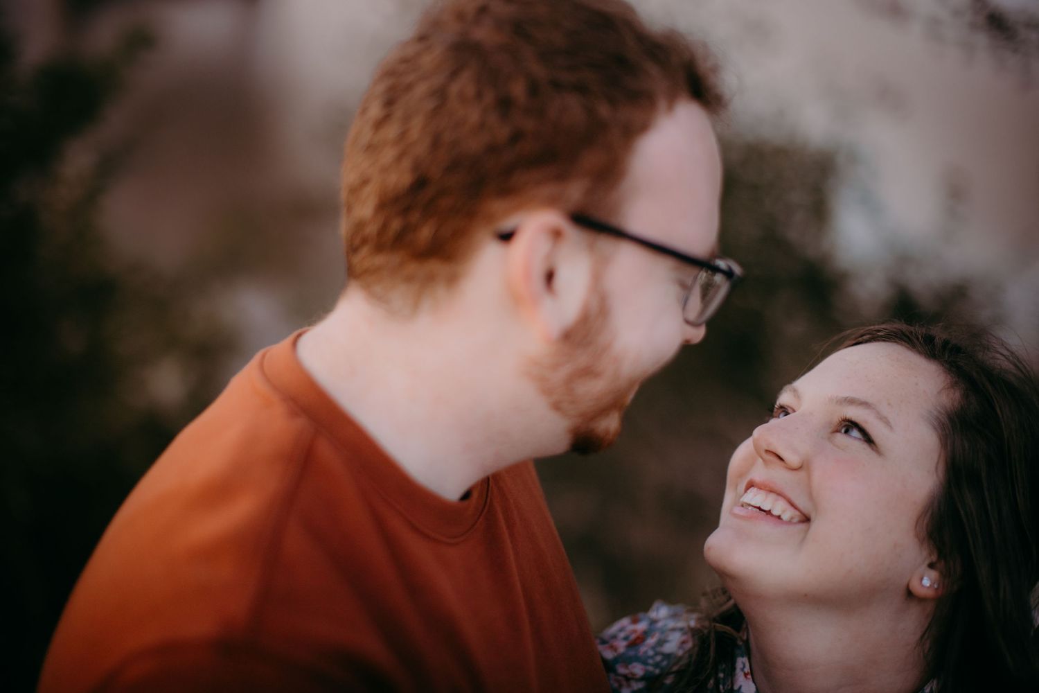 An intimate close-up of a couple sharing a joyful moment at sunset by the river.