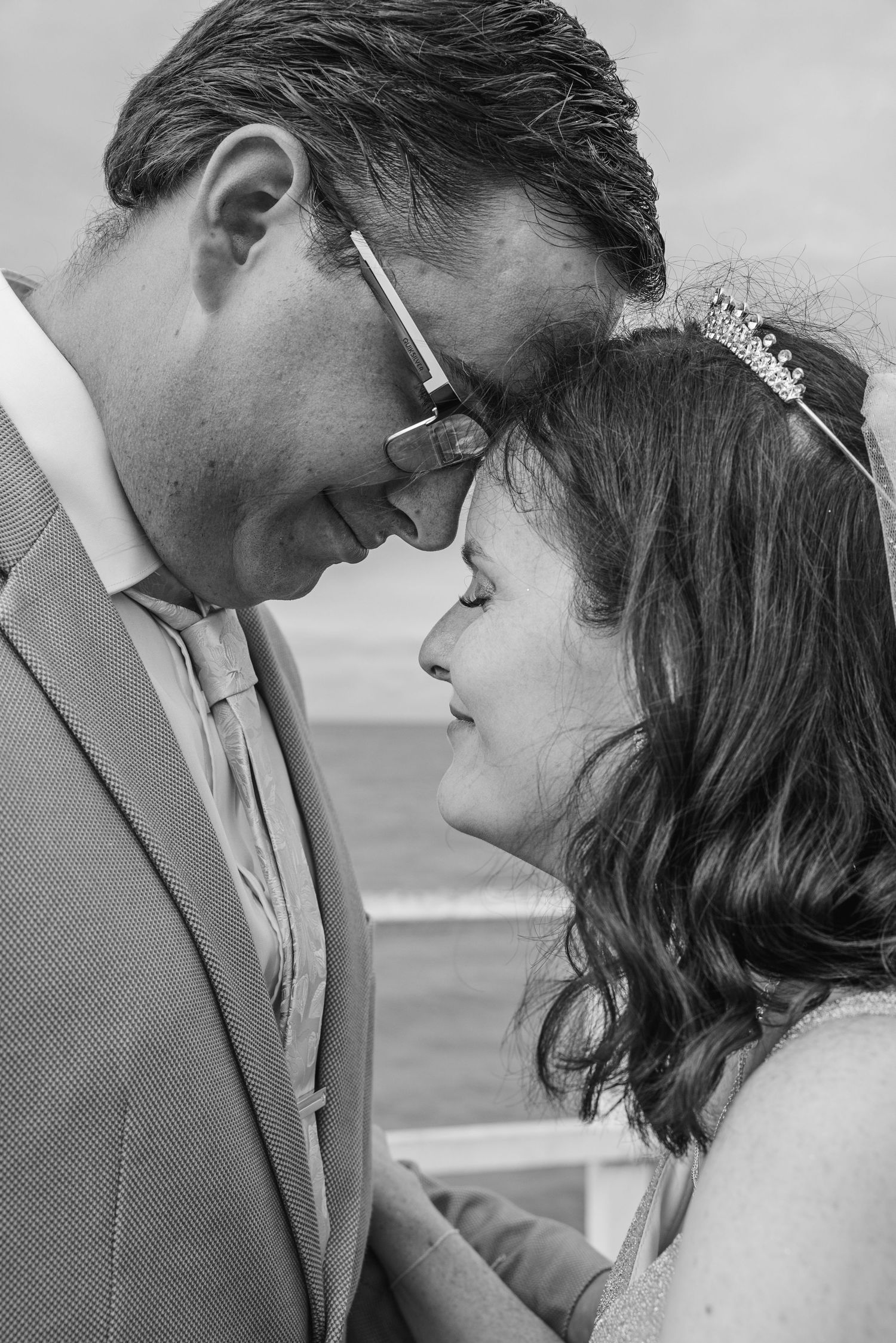 Intimate black and white portrait of couple sharing tender moment.