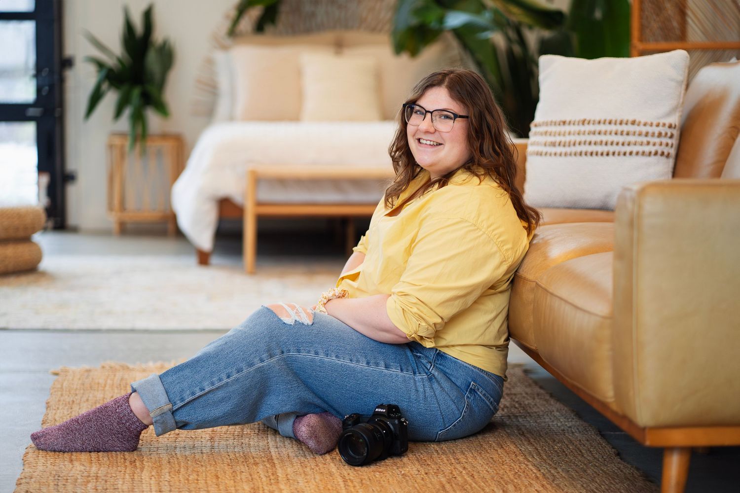 Westerville family photographer Maddie Lewis smiles while seated with her camera, ready to capture warm, joyful family moments.