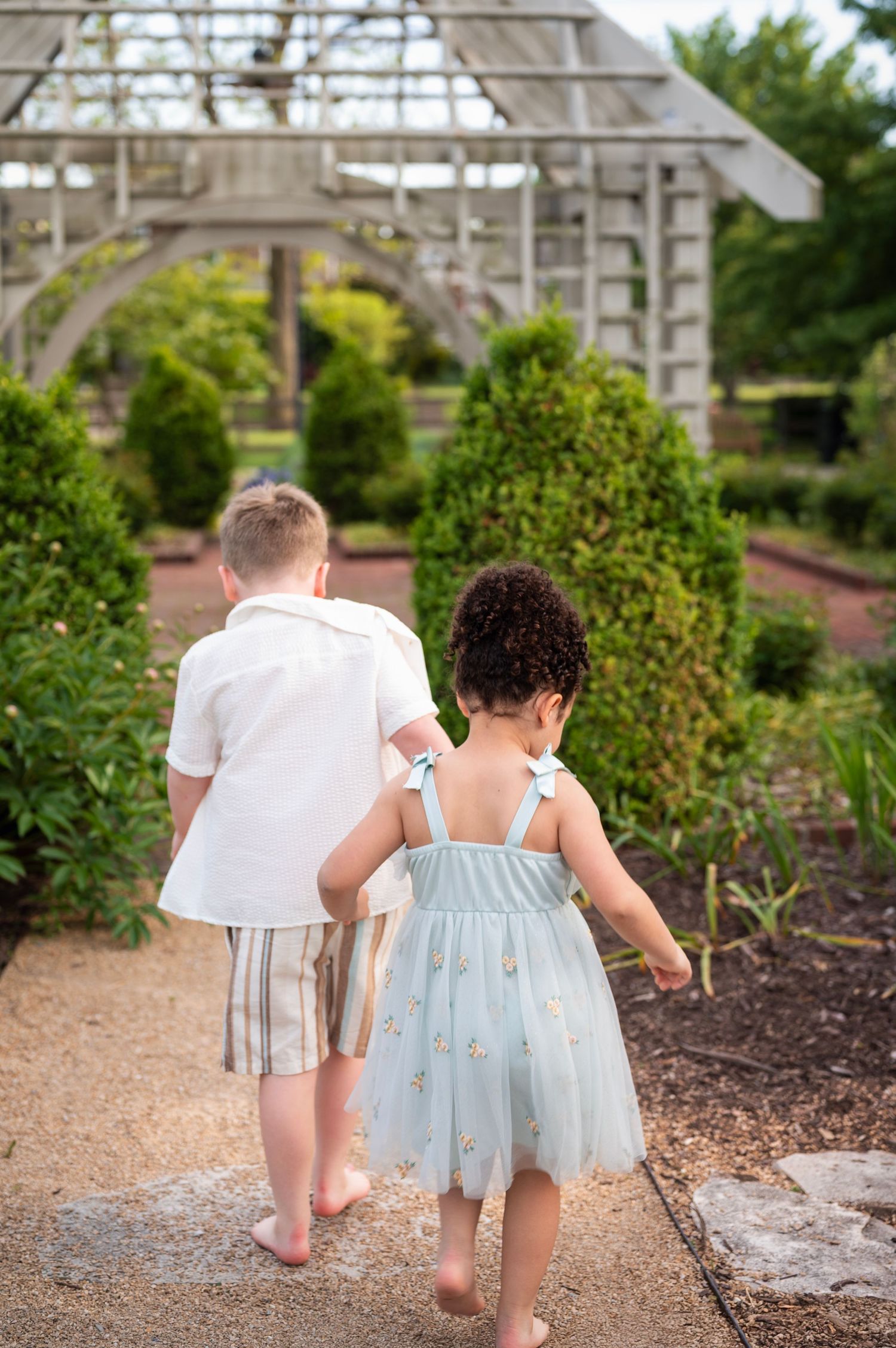 Young children leading the way through Franklin Park gardens during a spring photo session
