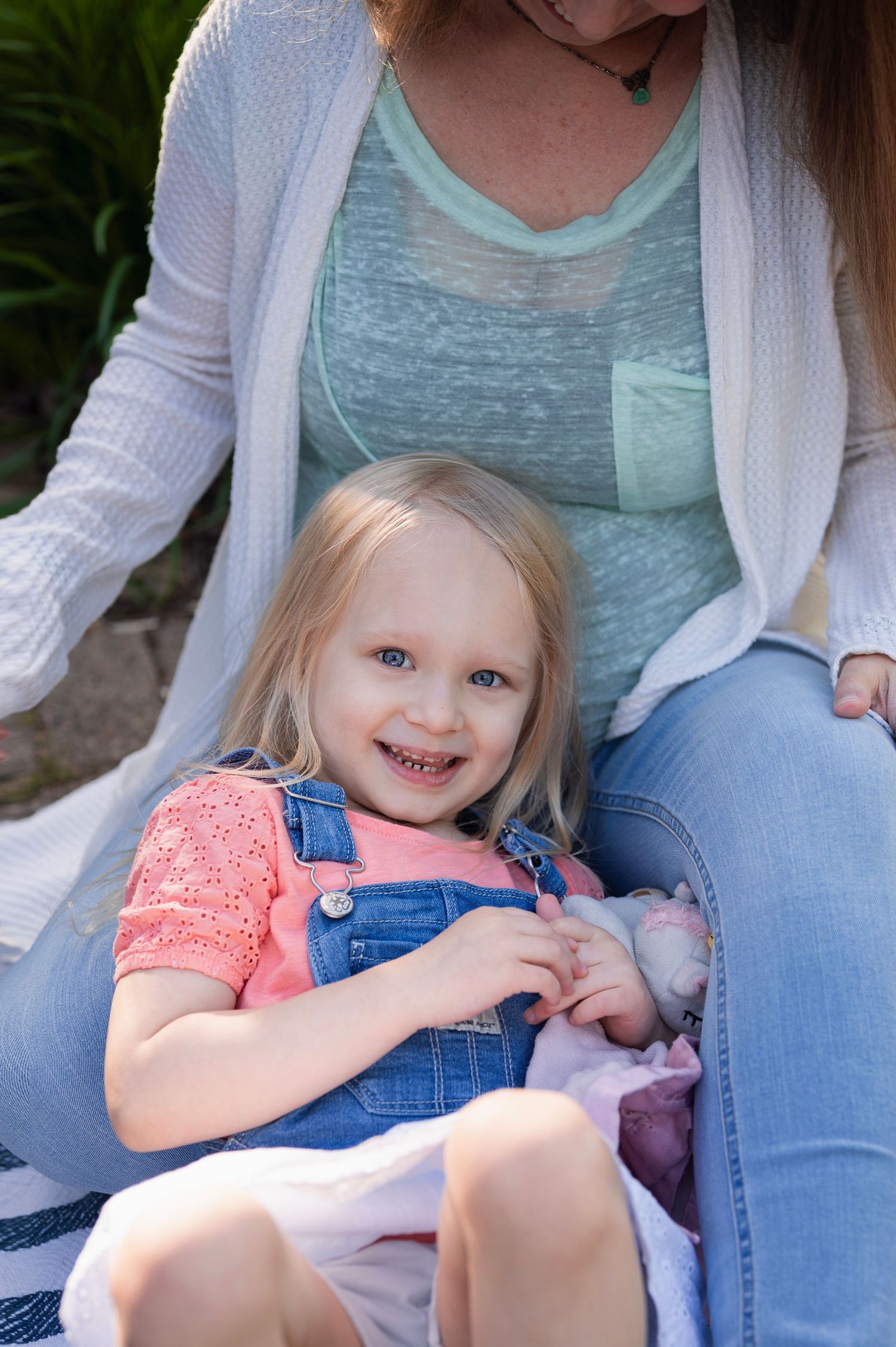 Young girl smiling up from her mother’s lap during a candid moment at a Boundless Joy mini session in Columbus