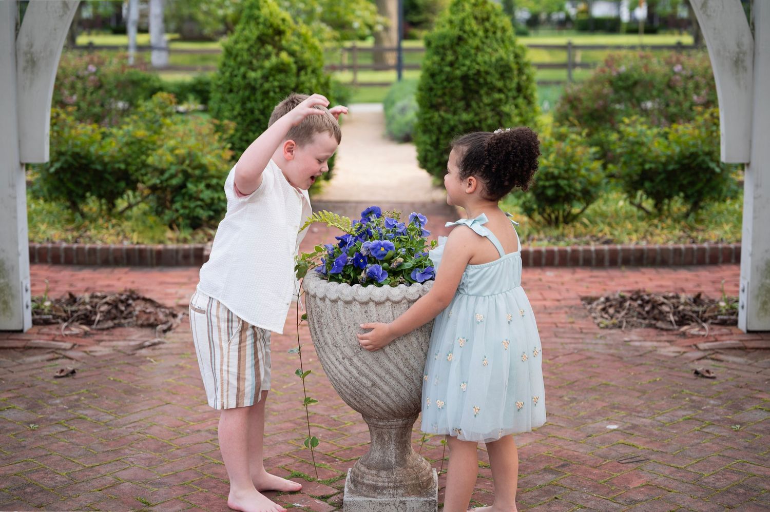 Brother and sister pretending with flowers at Franklin Park, full of laughter and imagination