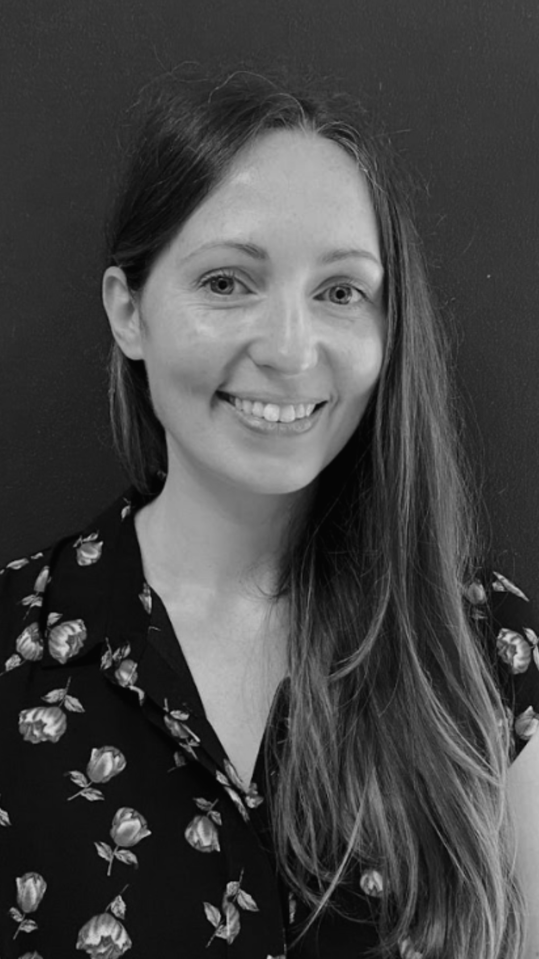 Black and white photo series showing someone wearing a floral print blouse with dark long hair against dark background.