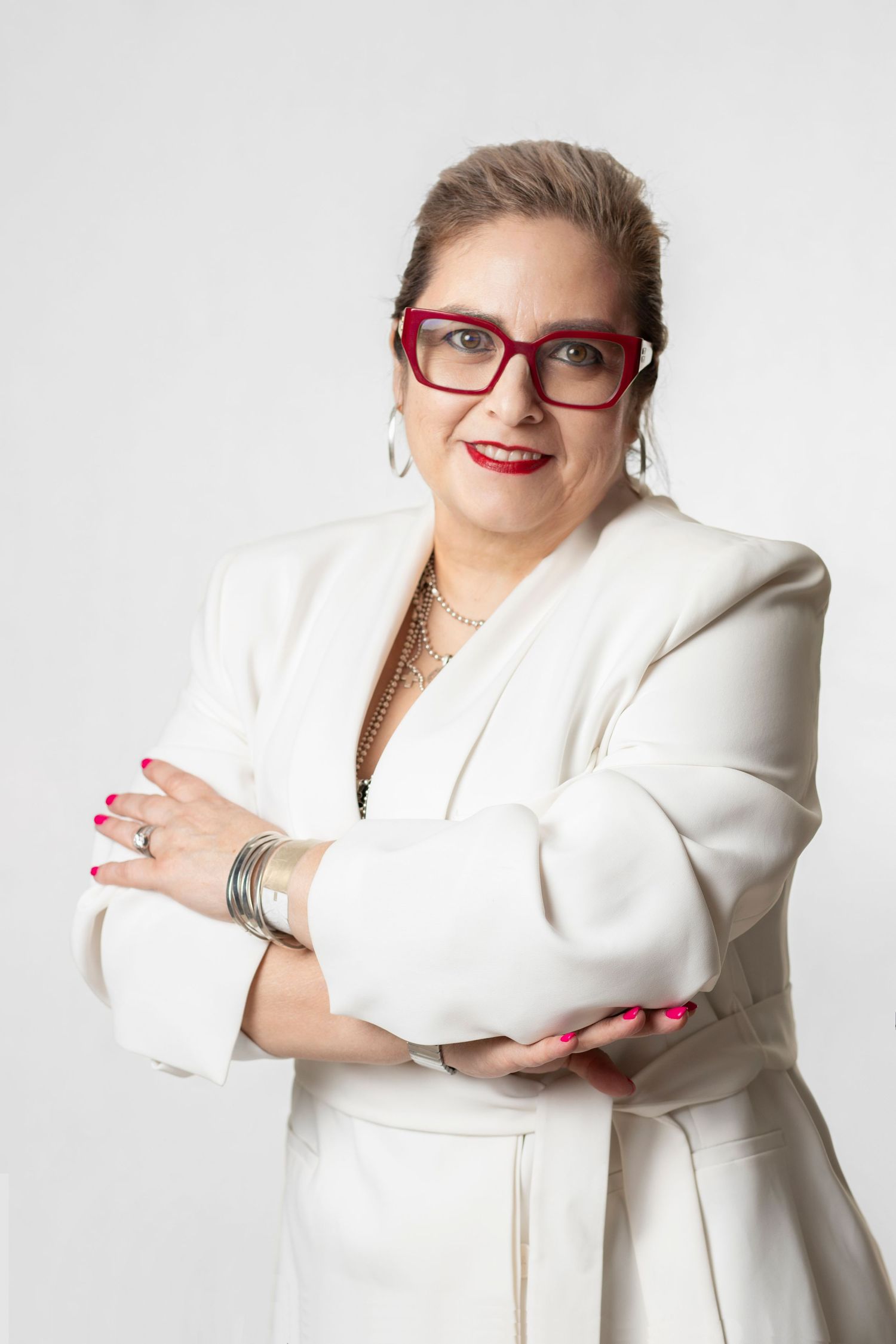 Professional in a white blazer with red glasses strikes confident poses against light background.