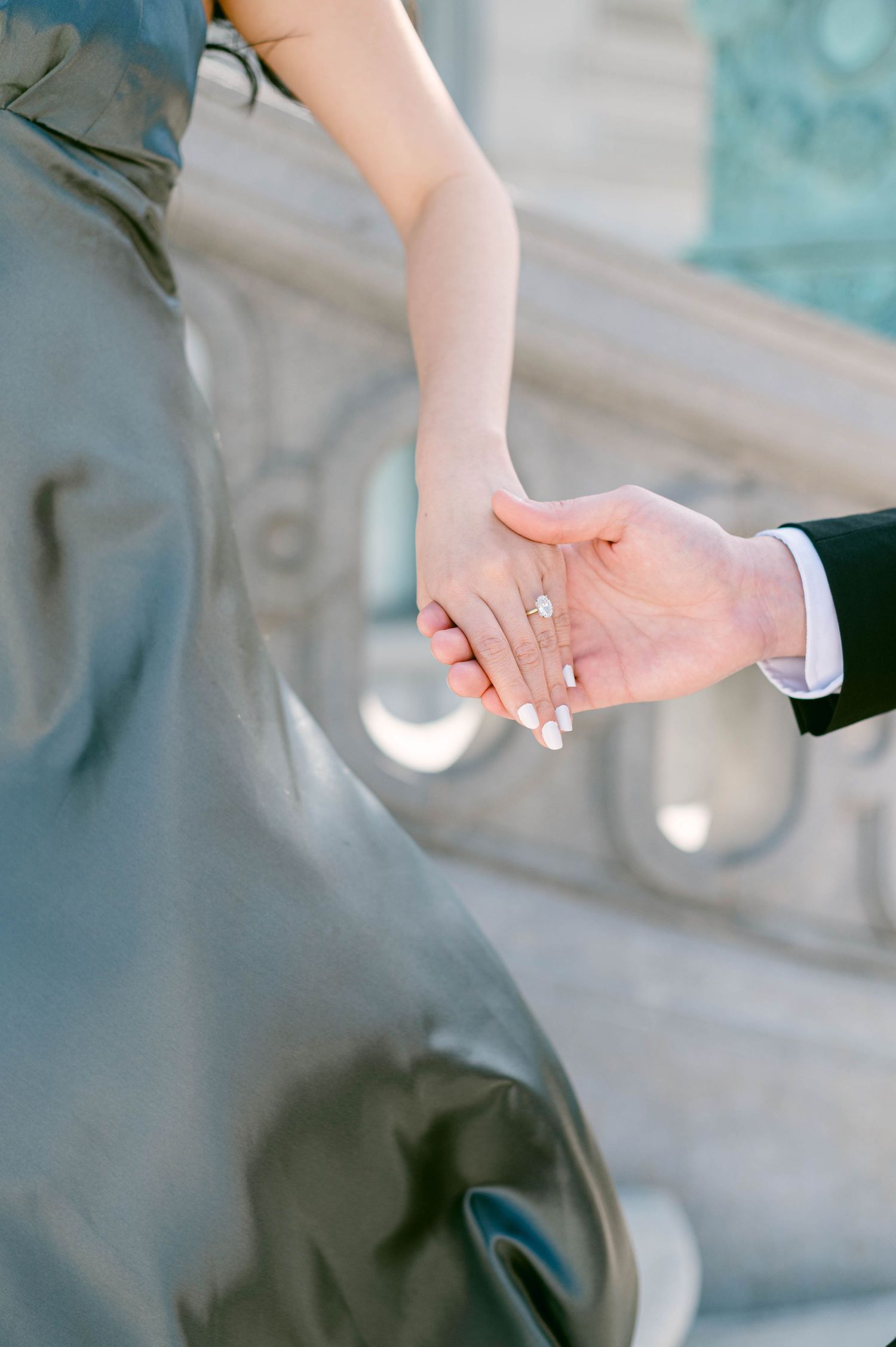 Close up of two hands touching gently in romantic wedding photography showing soft intimate moment against blurred background.