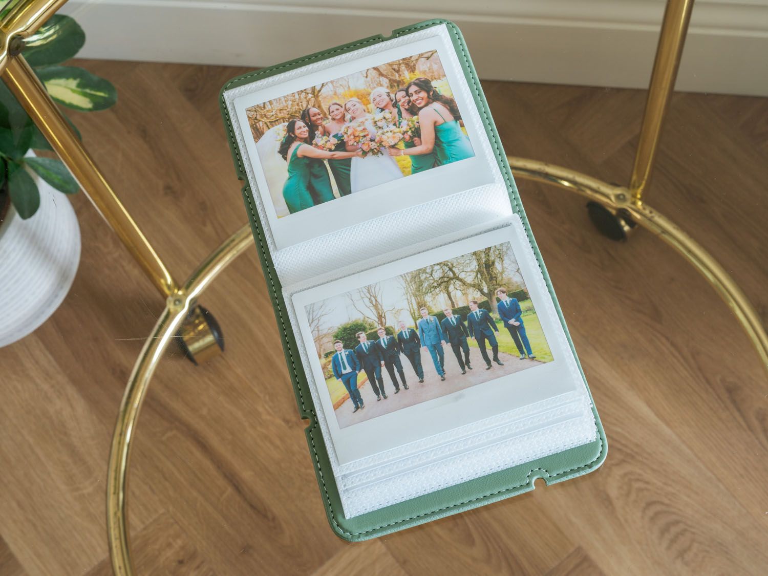 Wedding photo album displaying group celebration shots with mint green binding.