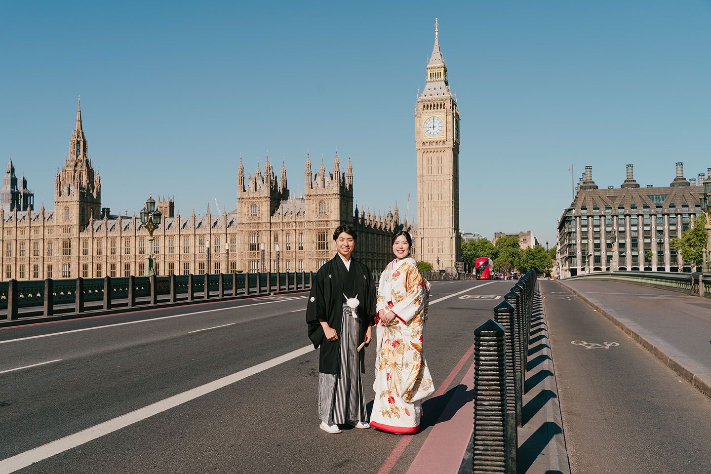 Tourists walking along Westminster Bridge in London with Big Ben and Parliament buildings visible in the background.